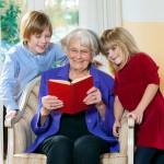 Grandmother Reading Book to Grand Children.
